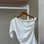 One shoulder drape white top with gold hardware